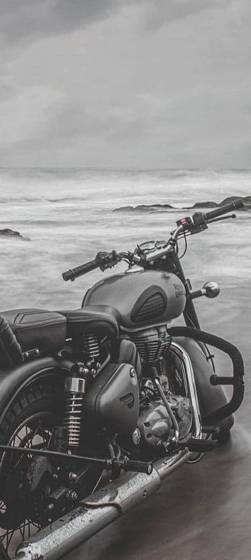 Monochrome Royal Enfield on Misty Shore Phone Backdrop