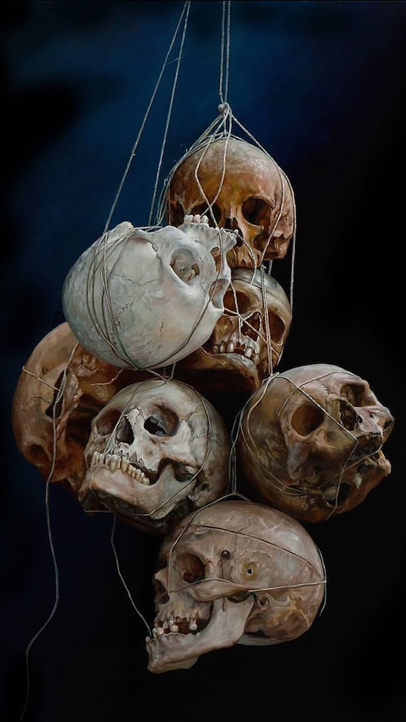 Human skulls with weathered textures hang from thin strings against a dark, shadowy void in vertical orientation.