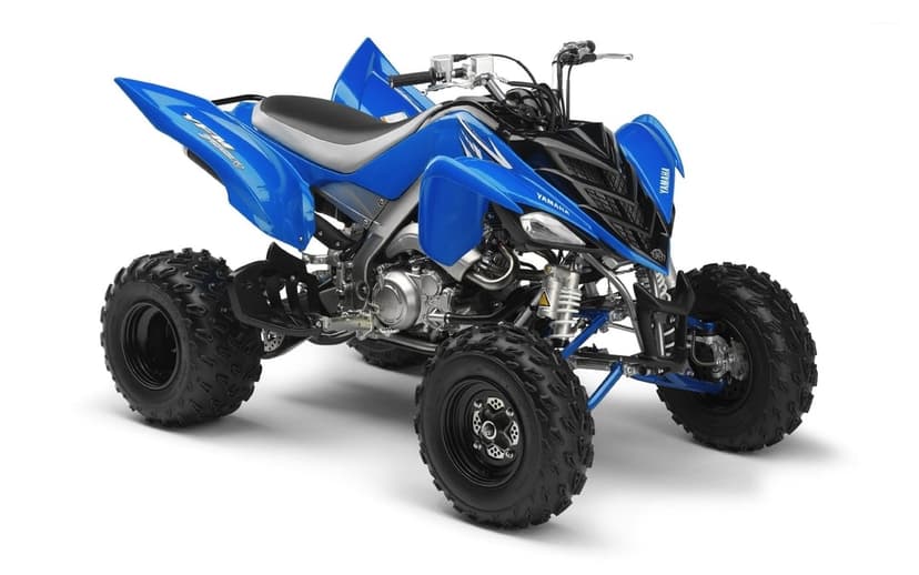 Blue Yamaha Raptor 700R sport ATV with knobby tires and aggressive styling on a white background.