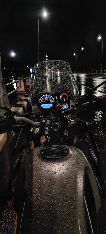 Rainy Night Motorcycle Ride: Wet Dashboard and Fuel Tank