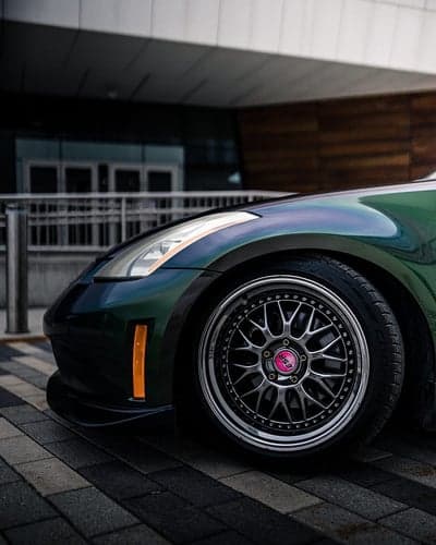 Green sports car wheel and bumper detail