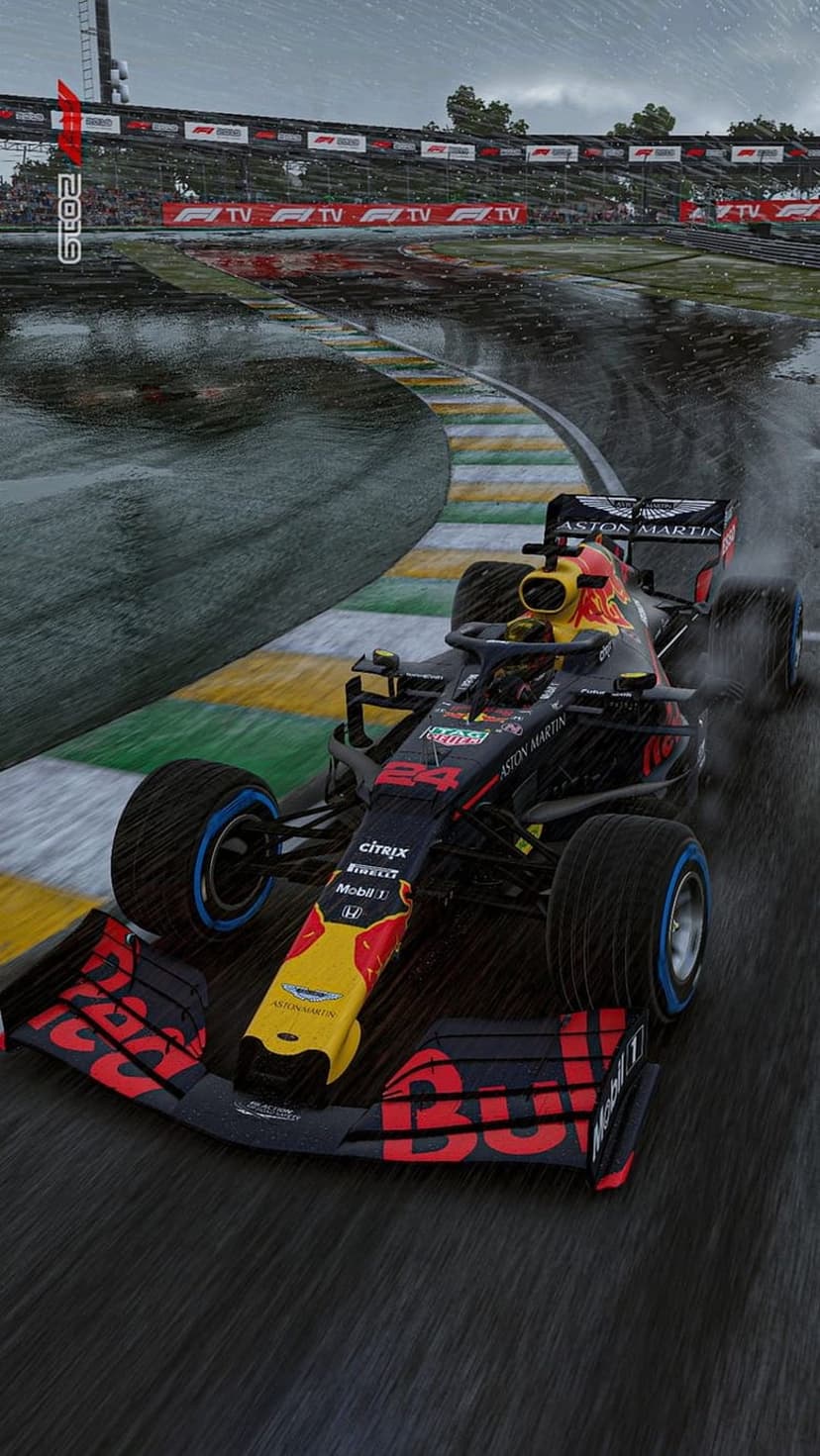 Red Bull Formula 1 car kicks up water spray while cornering on a wet racetrack during a rainy Grand Prix event.