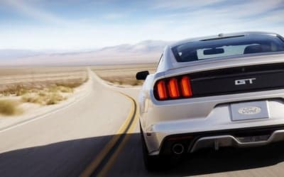 Silver Ford Mustang GT Rear View on Desert Highway Wallpaper