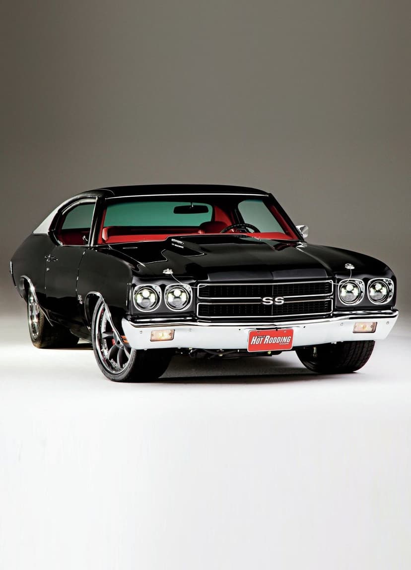 Black 1970 Chevrolet Chevelle SS muscle car with a red interior and modern LED headlights in a studio setting.