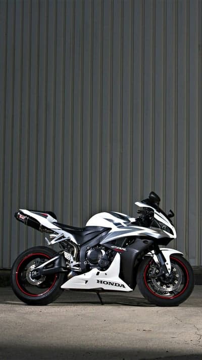White Honda CBR Motorcycle Parked Against Corrugated Wall