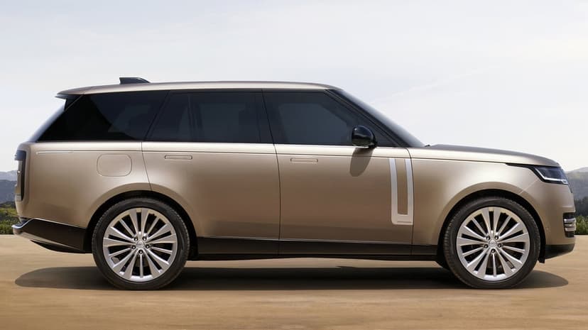 Champagne gold luxury SUV side profile with large silver wheels and a minimalist design under a clear sky.