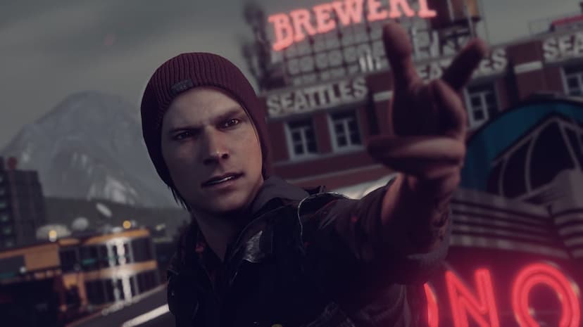Delsin Rowe in a red beanie gestures with his hand against a neon brewery sign and mountain backdrop at dusk.