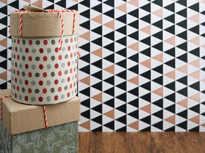 Festive Gift Boxes Stacked Against Geometric Pattern Wallpaper