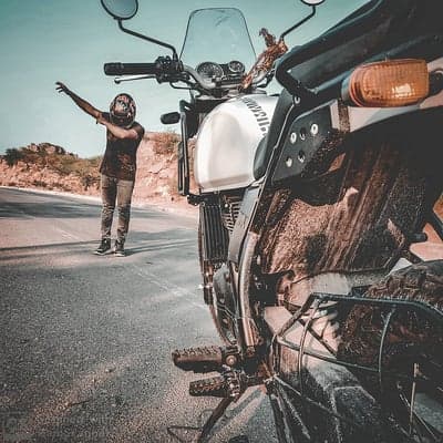 Man with motorcycle on dusty road