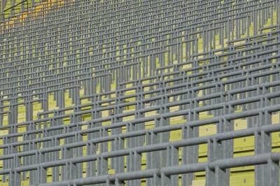 Rows of empty stadium seats with metal railings