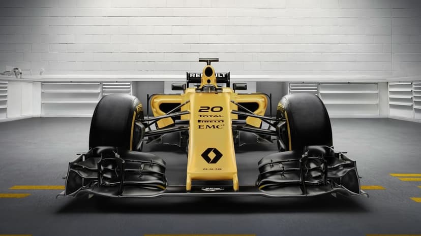 Front view of a yellow Renault Formula 1 car in a bright studio with a white brick background and wide tires.