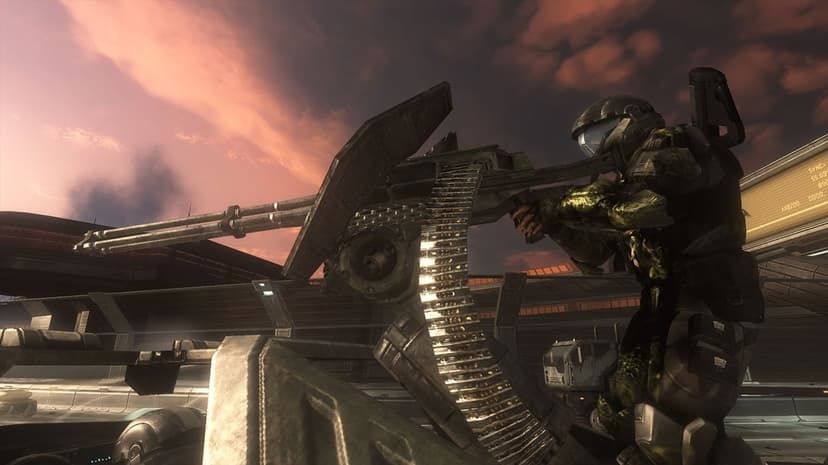 Armored soldier in green plating fires a large gatling gun turret against an orange and purple sunset sky.
