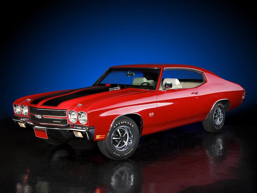 Red 1970 Chevrolet Chevelle SS with black hood stripes and white interior on a reflective studio floor.