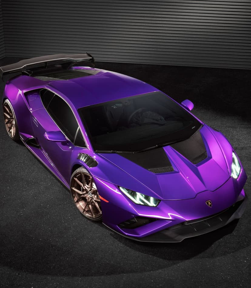 Purple Lamborghini supercar featuring bronze alloy wheels and a rear spoiler against a dark textured backdrop.
