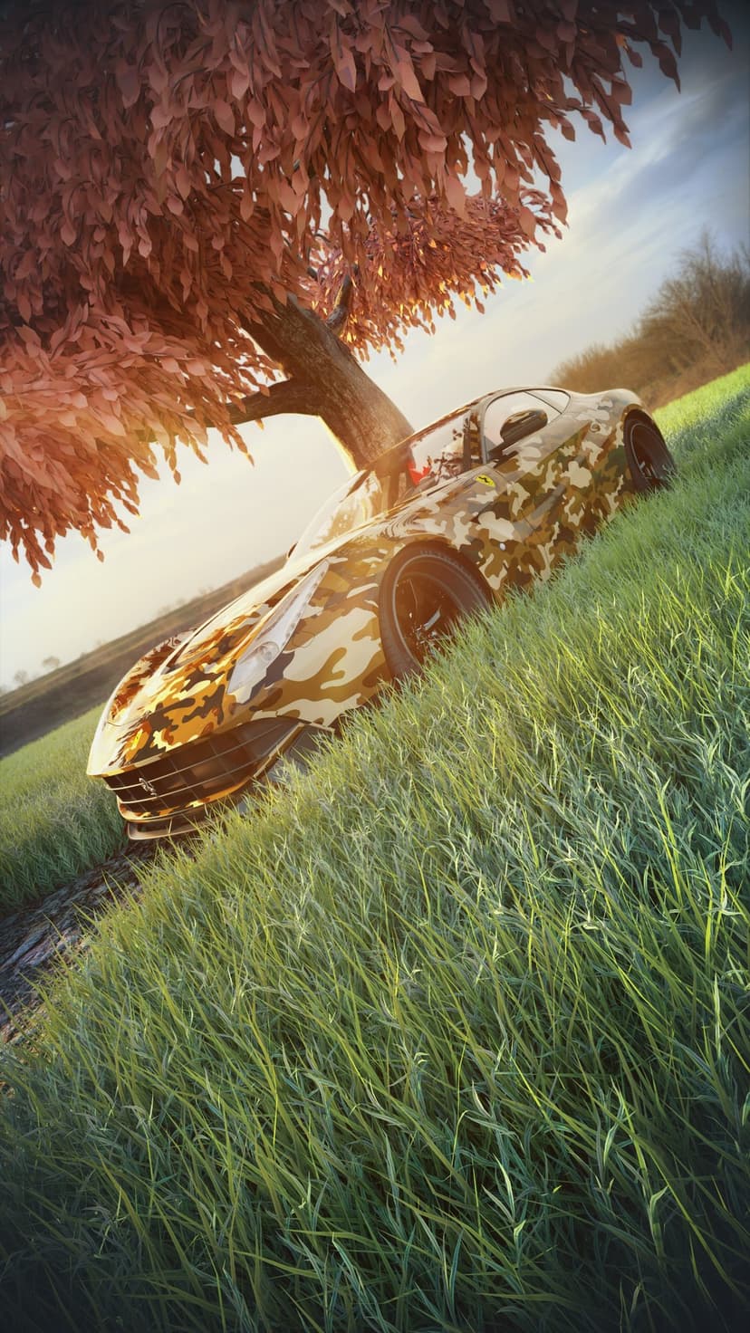Camouflage Ferrari sports car parked on green grass under a tree with red leaves during golden hour sunlight.