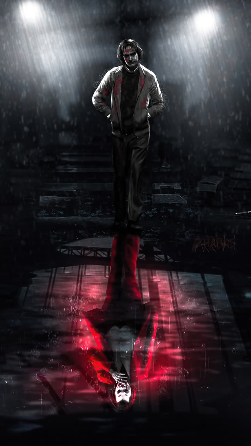 Joker stands in a wet Gotham alleyway with his distorted red reflection visible on the rain-soaked pavement.