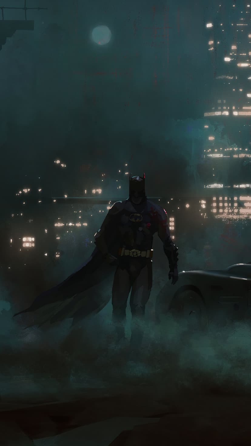 Batman in a black suit stands before the Batmobile in a smoky Gotham street with a glowing skyline behind him.