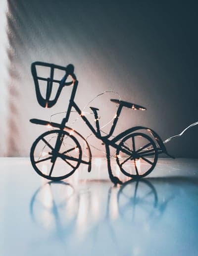 Silhouette Bicycle with Fairy Lights on Reflective Surface