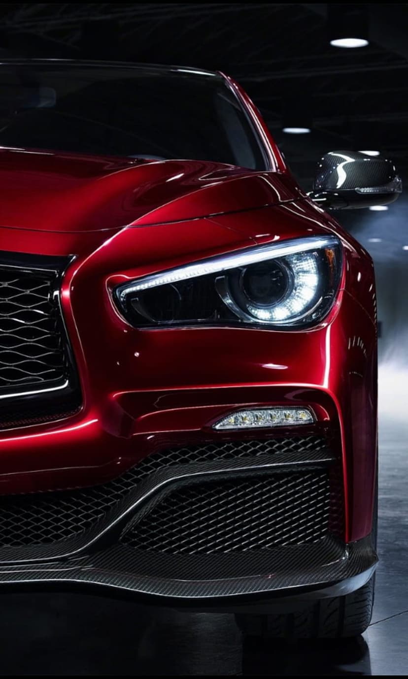 Red supercar front headlight with glowing LED lights, carbon fiber accents, and a black mesh grille detail.