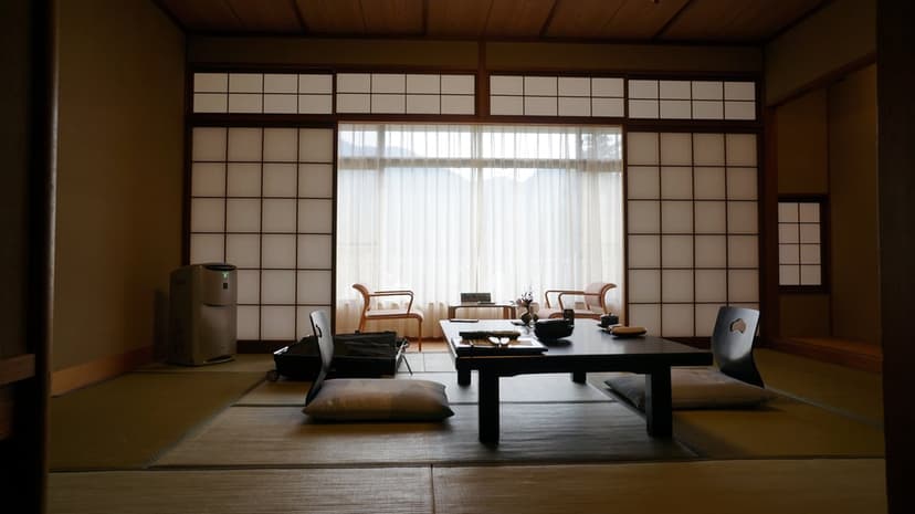 Low wooden tea table on tatami mats inside a Japanese room with shoji screens and soft natural light.