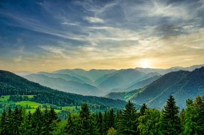 Misty Mountain Range at Sunrise with Lush Green Forests