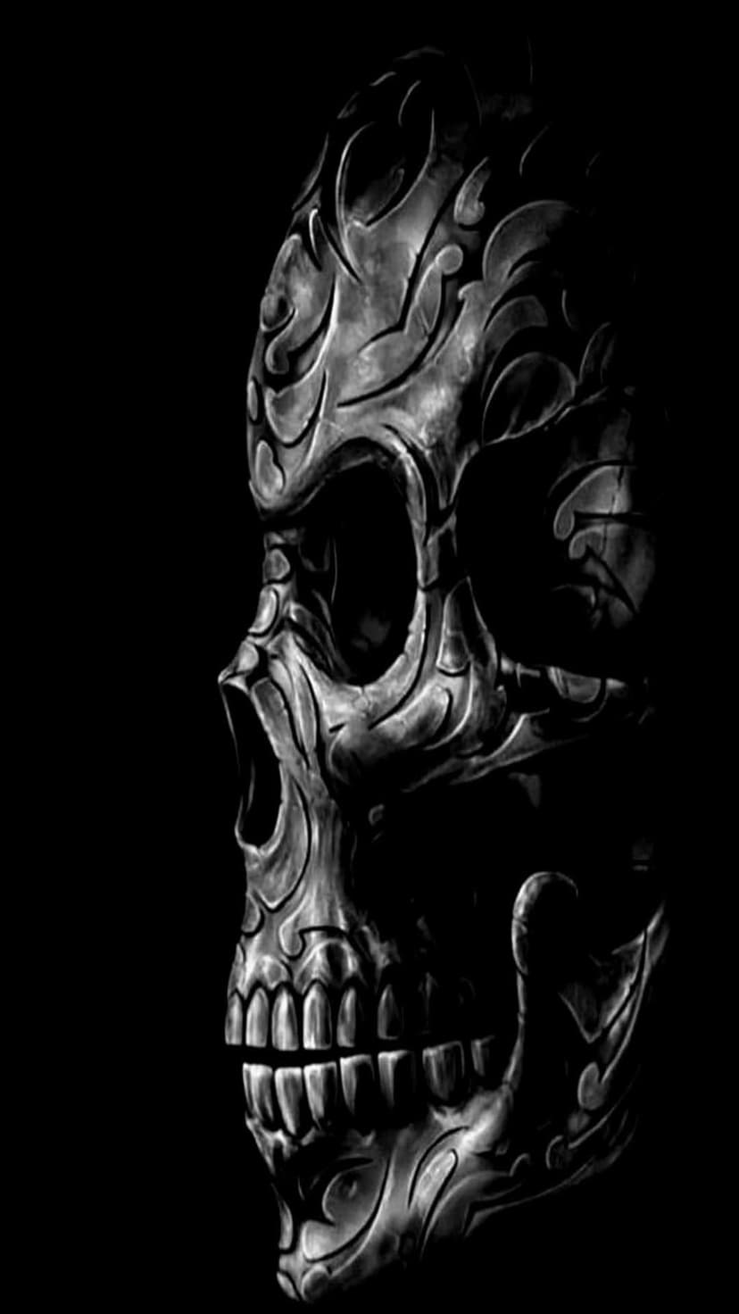 Human skull with intricate tribal carvings and geometric patterns set against a solid black background.