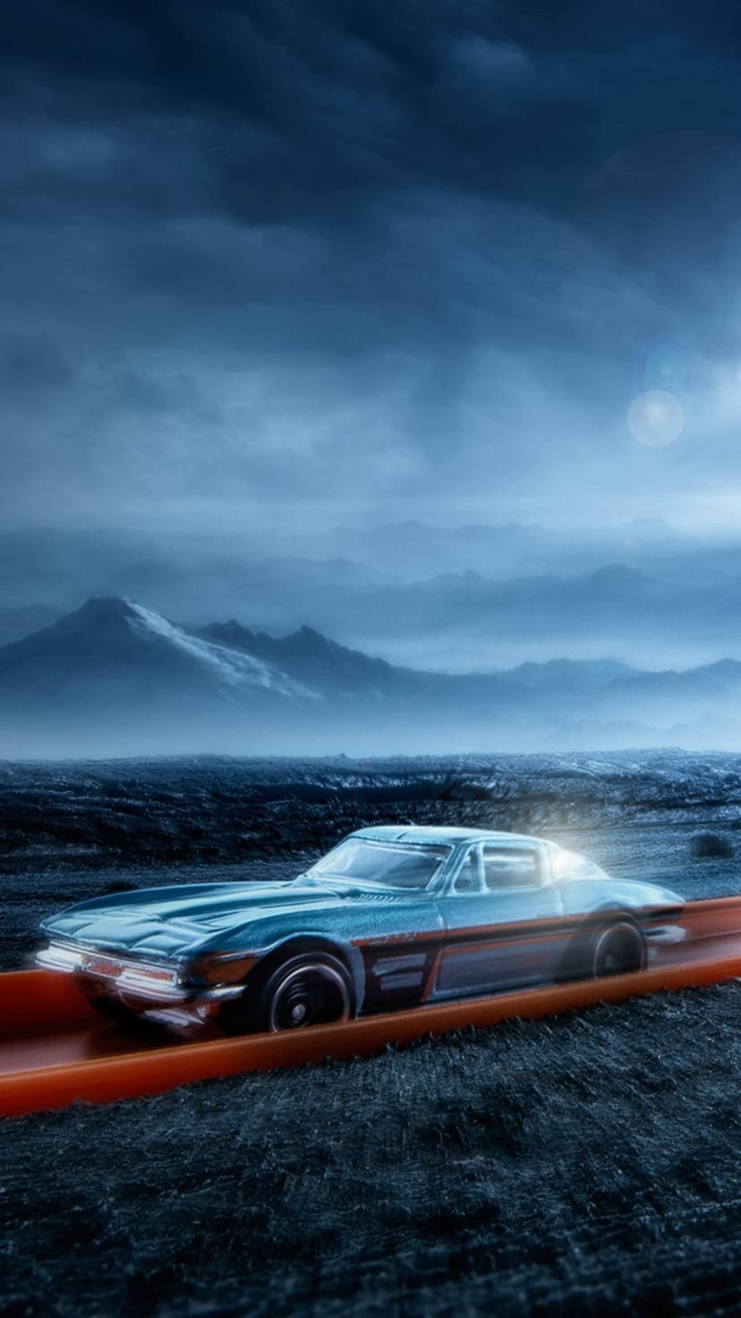 Blue classic toy car racing on an orange track with misty mountains and a dark cloudy sky in the background.