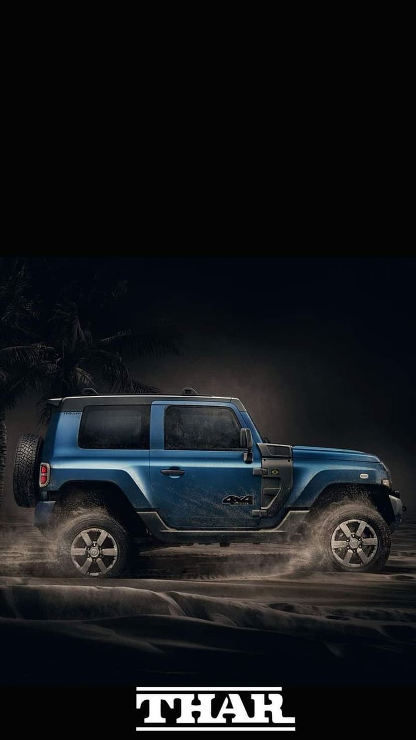 Blue Mahindra Thar SUV drifting through sand dunes with palm tree silhouettes against a dark atmospheric sky.