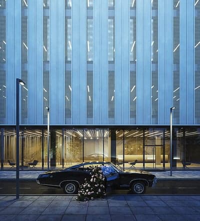 Black car overflowing with flowers by modern building