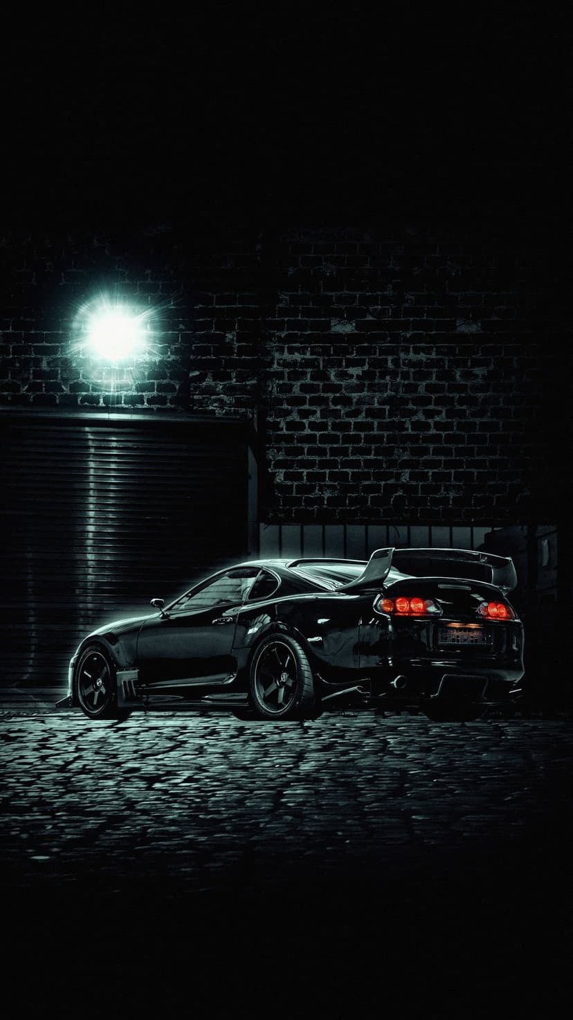 Black Toyota Supra parked on wet cobblestones in a dark alley illuminated by cool blue neon light from a brick wall.