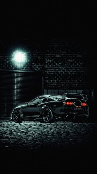 Sleek Black Supra in Dark Alleyway with Neon Glow