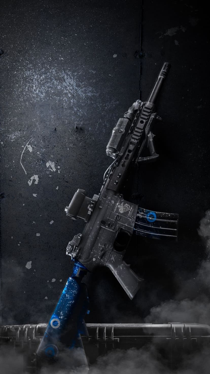 Tactical carbine rifle with blue magazine accents and scope rests against a dark, smoky backdrop.