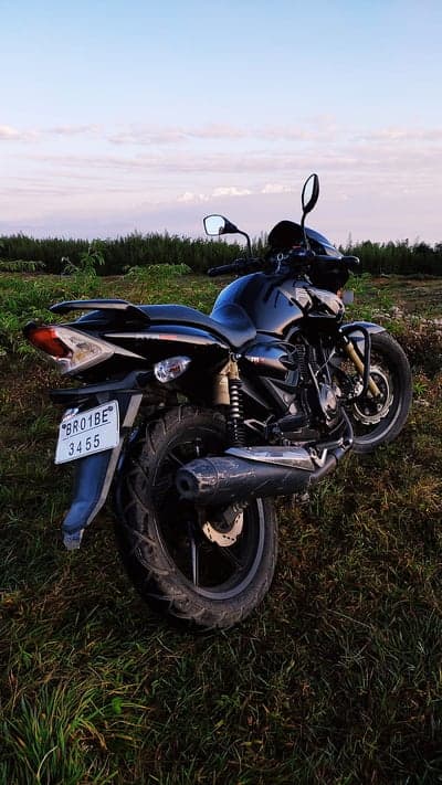 Black Motorcycle Parked in Grassy Field at Dusk