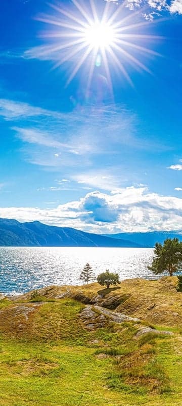 Sunny Lake and Mountains Landscape with Green Hills