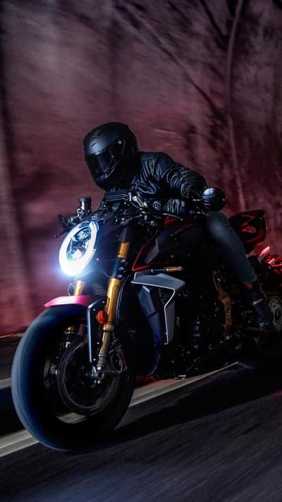 Motorcyclist in leather riding a black motorcycle through a tunnel