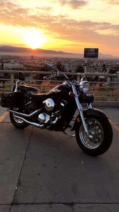 Cruiser Motorcycle at Sunset Over Cityscape
