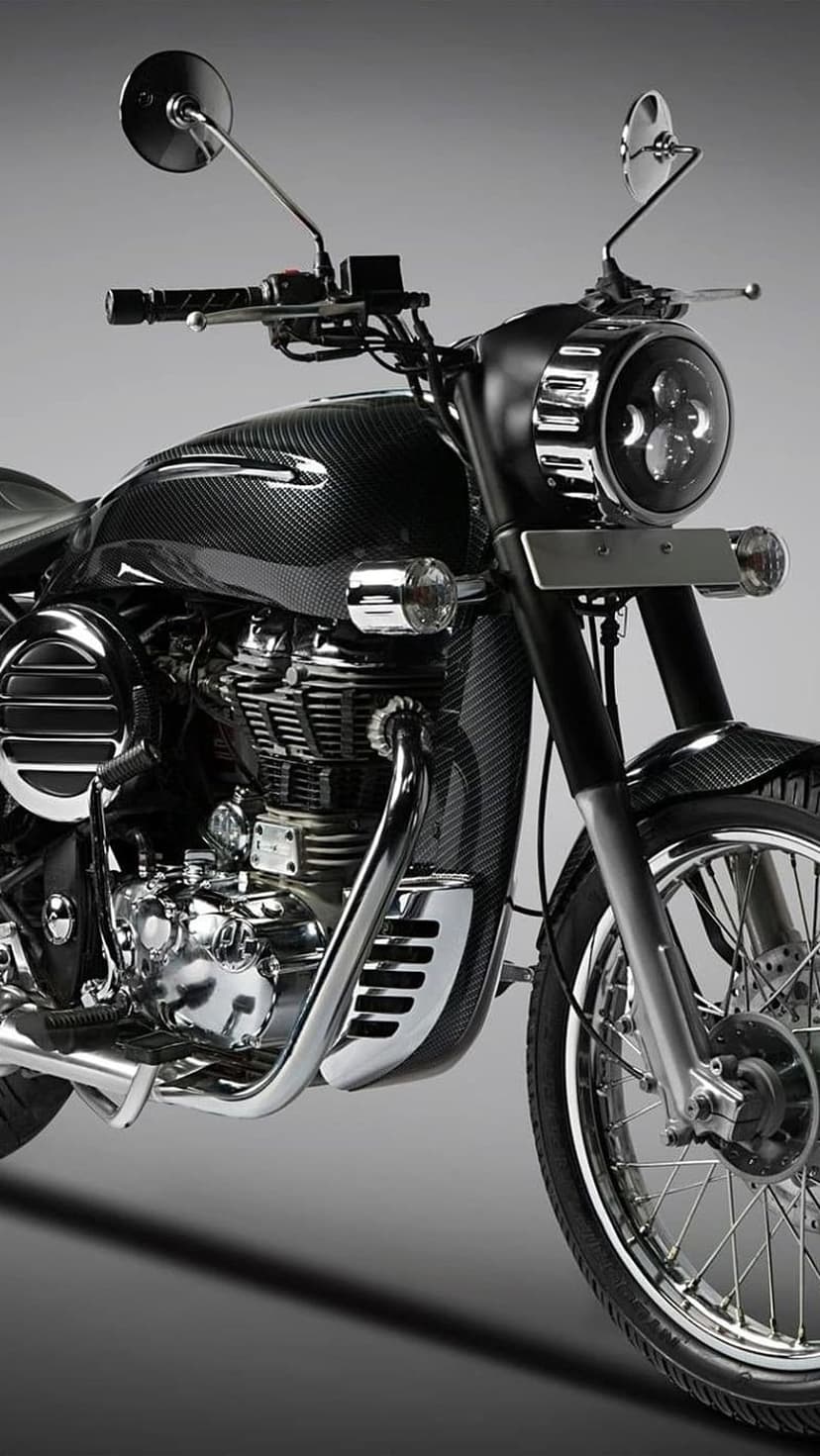 Custom carbon fiber motorcycle with a round LED headlight and chrome engine details on a dark vertical backdrop.