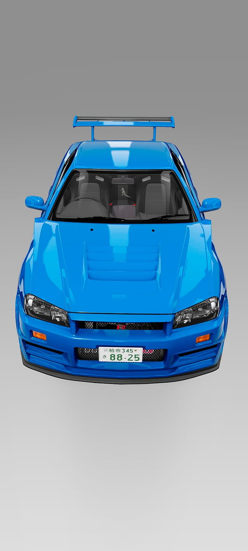Blue Nissan Skyline R34 GT-R sports car with a large rear wing spoiler shown on a studio gray background.