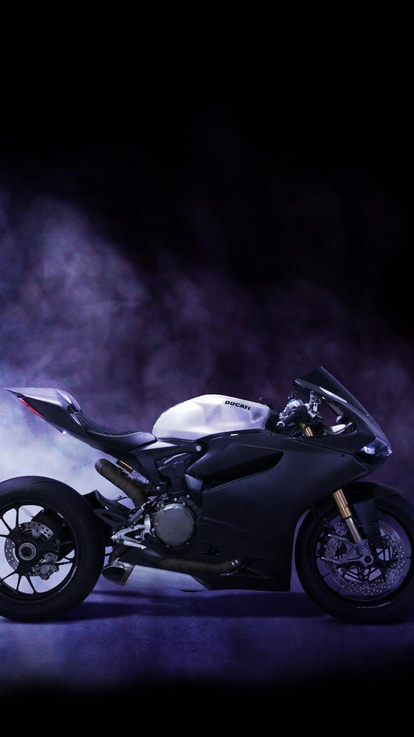 Ducati superbike featuring a white tank is partially obscured by swirling violet mist in a dark setting.