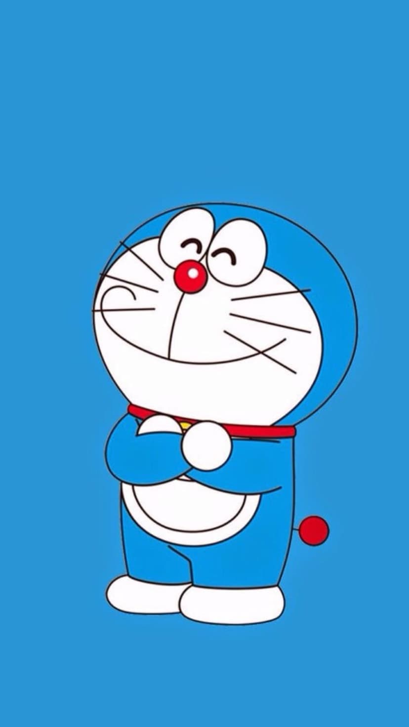 Doraemon smiles with crossed arms against a solid blue background, showing his red nose and white facial features.