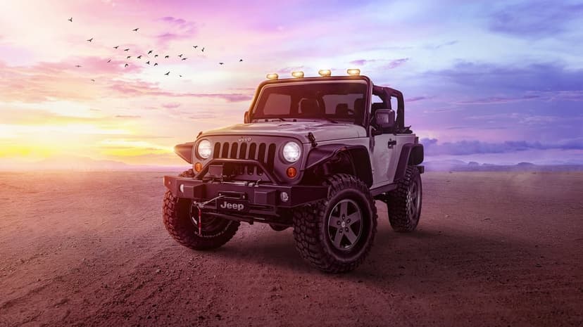 Silver Jeep Wrangler with off-road tires parked in a desert under a purple and orange sunset sky with birds.