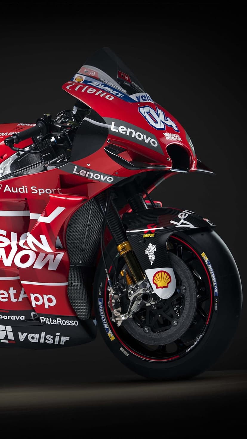 Ducati MotoGP motorcycle with red fairings, Lenovo logos, and the racing number 04 on a vertical racing track.