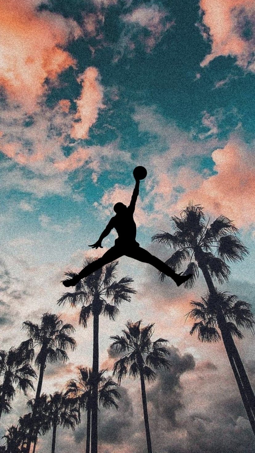 Jumpman silhouette dunks toward a hoop in a pink sunset sky with dark palm tree shapes at the base.