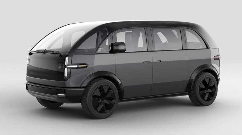 Modern gray electric van with a wrap-around windshield and black wheels centered in a bright white studio space.