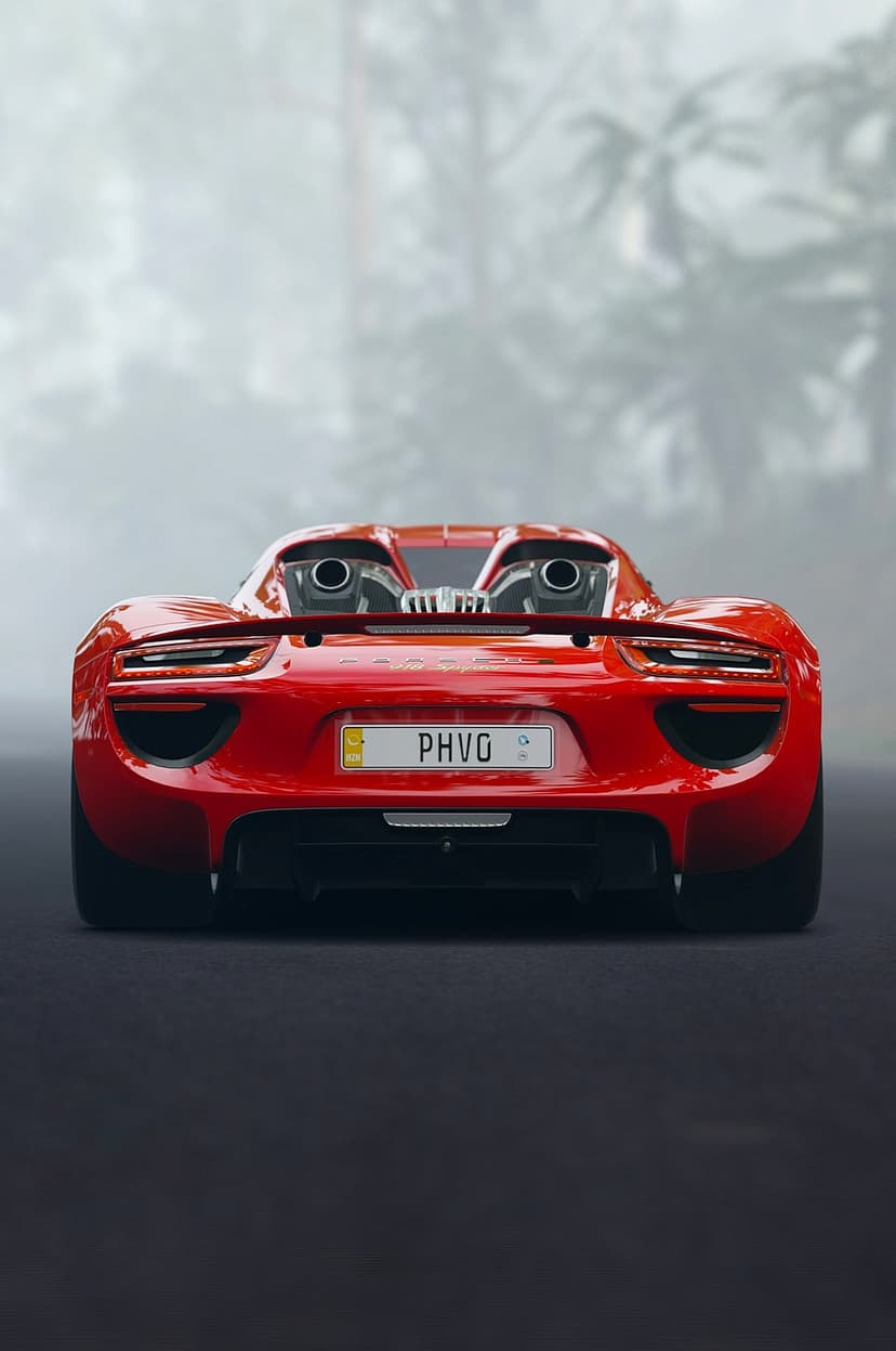 Red Porsche 918 Spyder rear showing twin exhausts and thin LED taillights through a thick layer of grey fog.