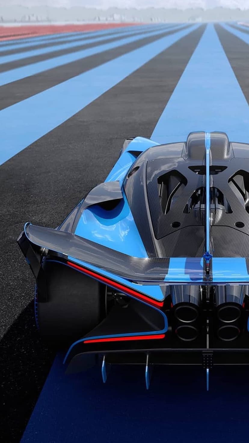 Bugatti Bolide rear view showing carbon fiber wings and X-shaped lights on a blue and black striped racing track.
