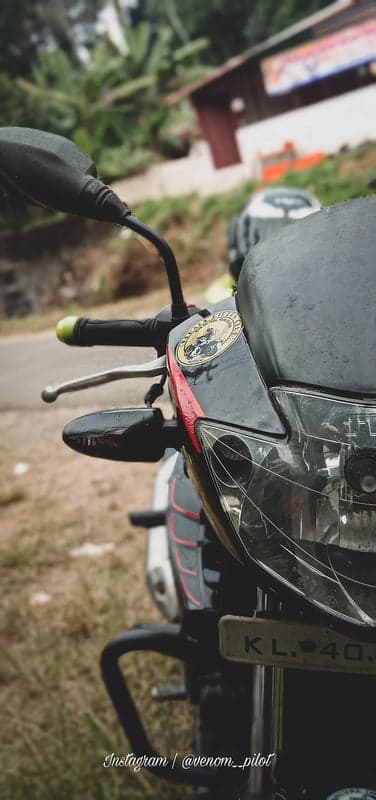 Close-up of motorcycle front, black and red accents, outdoor setting