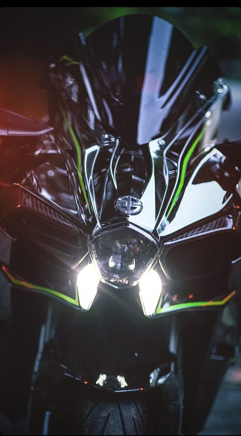 Kawasaki Ninja H2R front fairing with glowing LED headlights and green accents in a dark atmospheric setting.