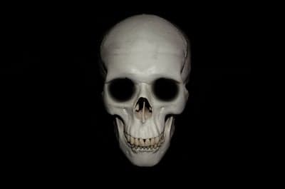 Eerie Human Skull with Dark Eye Sockets on Black