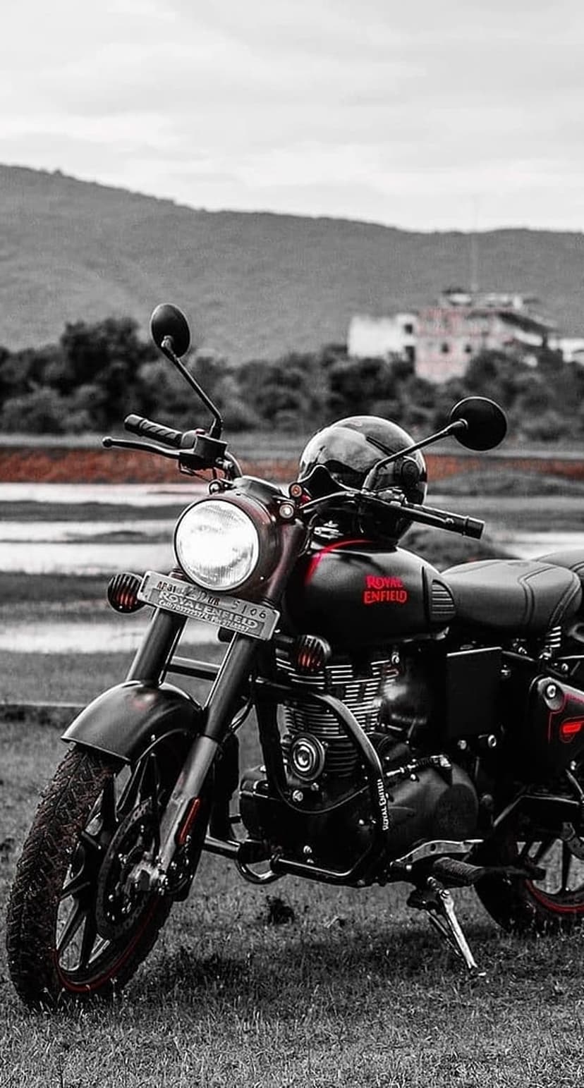 Royal Enfield Classic motorcycle with a black helmet on the tank, featuring selective red logo and rim details.